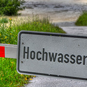 Hochwasserschild vor einer Wiese