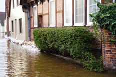 Hochwasser vor Fachwerkhaus mit Sandsäcken davor