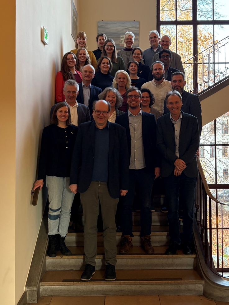Vertreterinnen und Vertreter des NLWKN und der NLPVW stehen mit dem Minister auf einer Treppe.