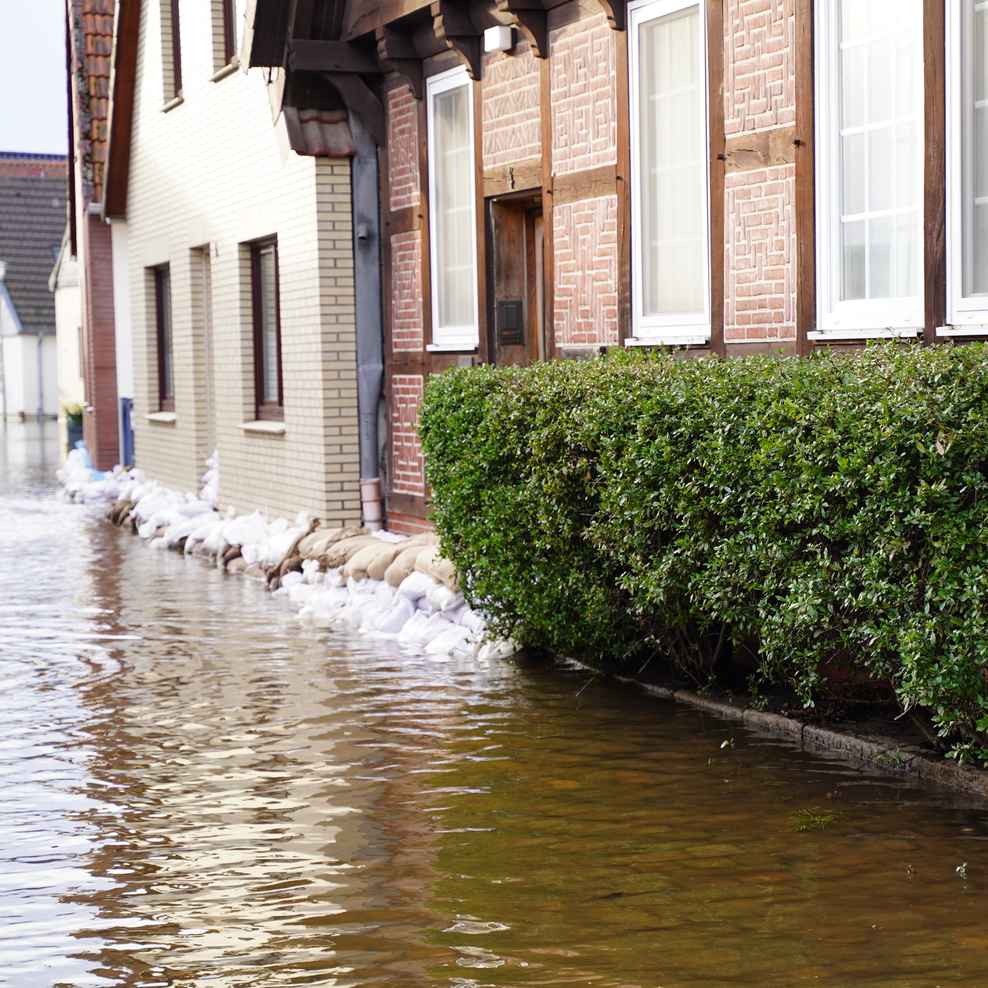 Hochwasser vor Fachwerkhaus mit Sandsäcken davor