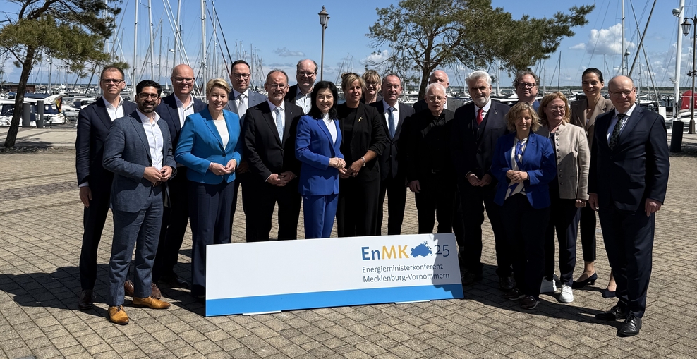 Die Energieminister der 16 Bundesländer und Bundesenergieministerin Reiche vor Boten in einem Hafen.