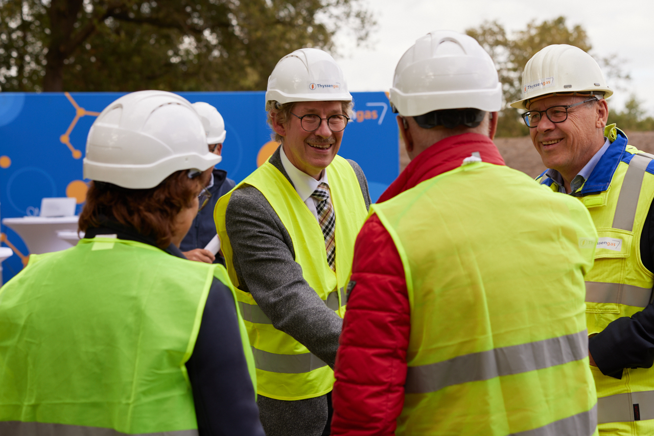 Umweltstaatssekretär Frank Doods und Mitarbeiter von Thyssengas unterhalten sich, alle tragen Helme und Warnwesten